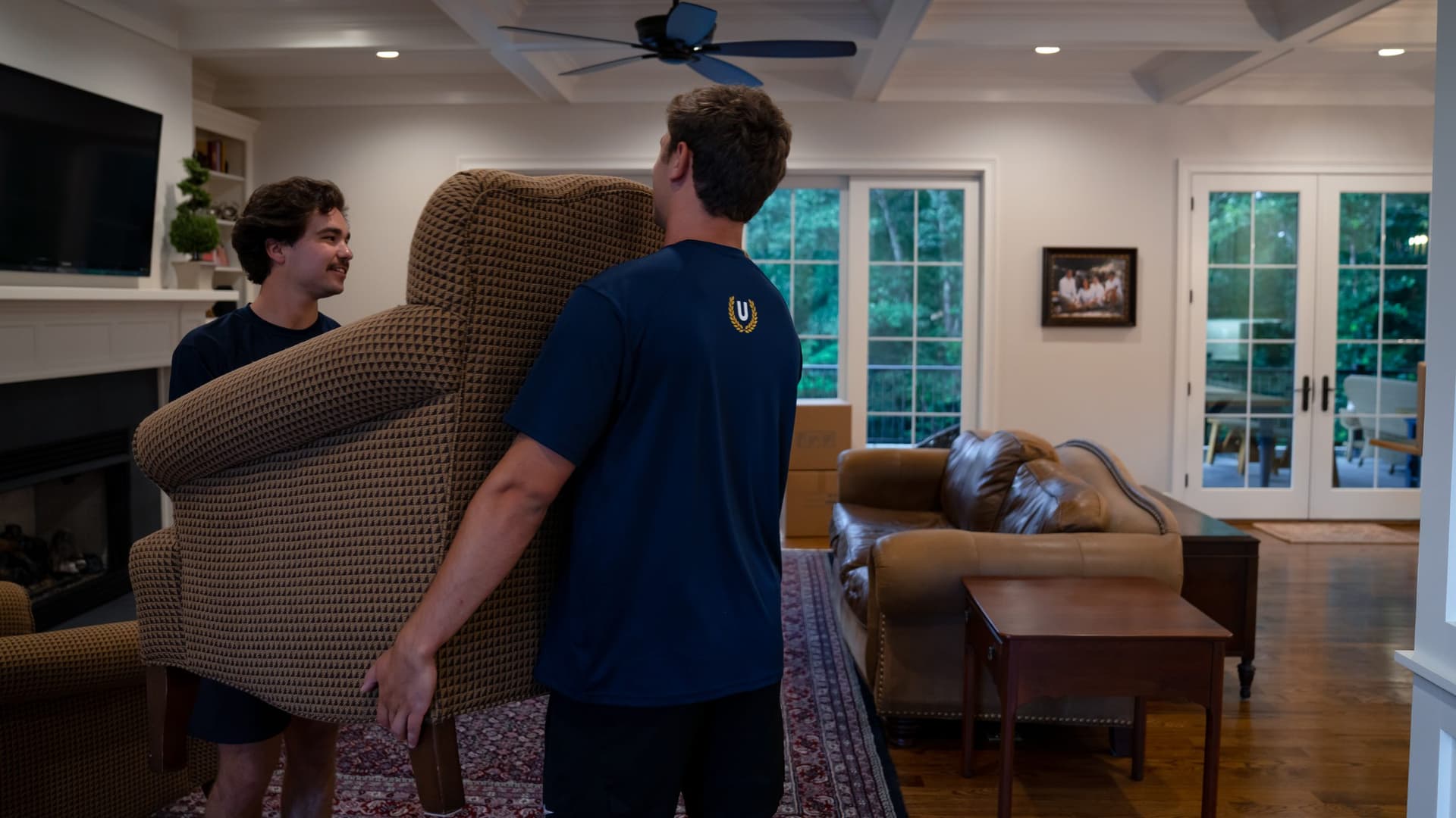 Undergrads crew carrying an armchair